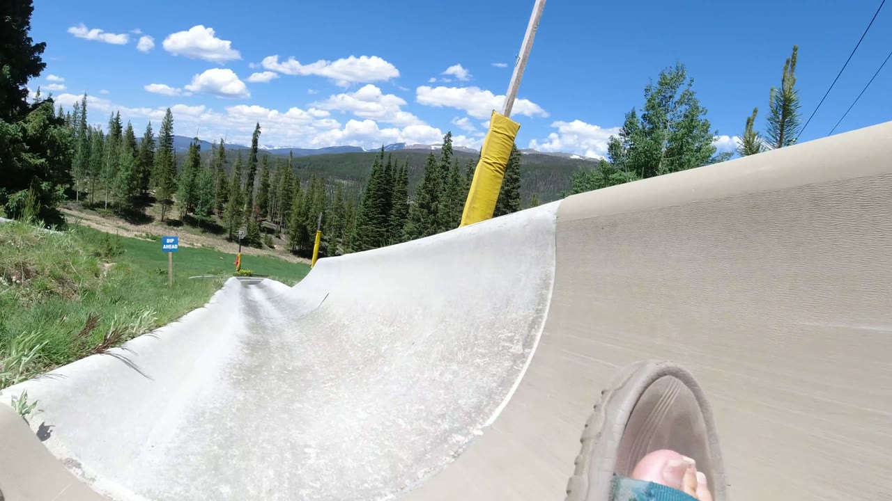 POV view down a concrete alpine slide with a sandal in the foreground