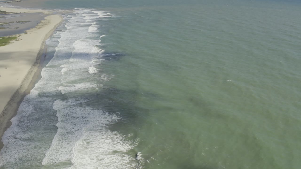 Aerial beach and ocean view with long bands of white surf.