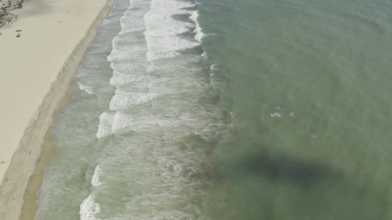 Diagonal shoreline with foamy waves and open water.