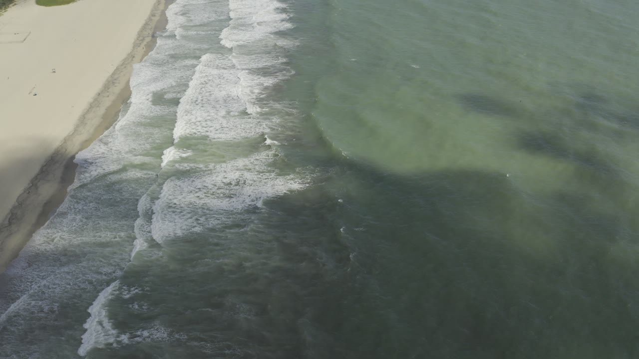 Foam lines breaking over green ocean near shore