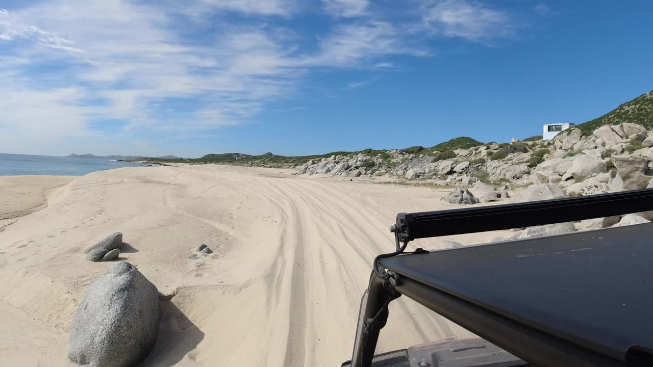 Vehicle foreground on a sandy beach road beside the ocean