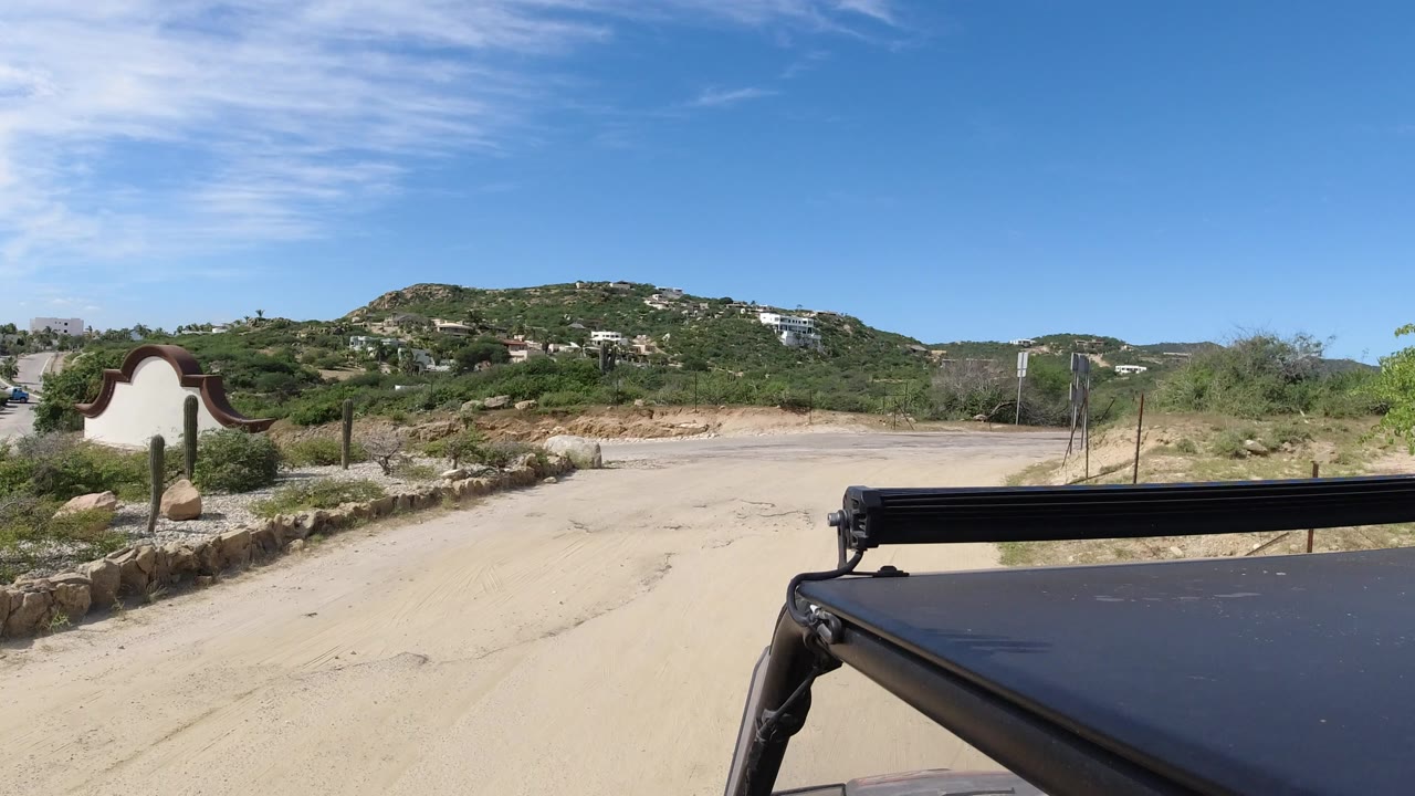 Truck-side view of sandy junction and green hills