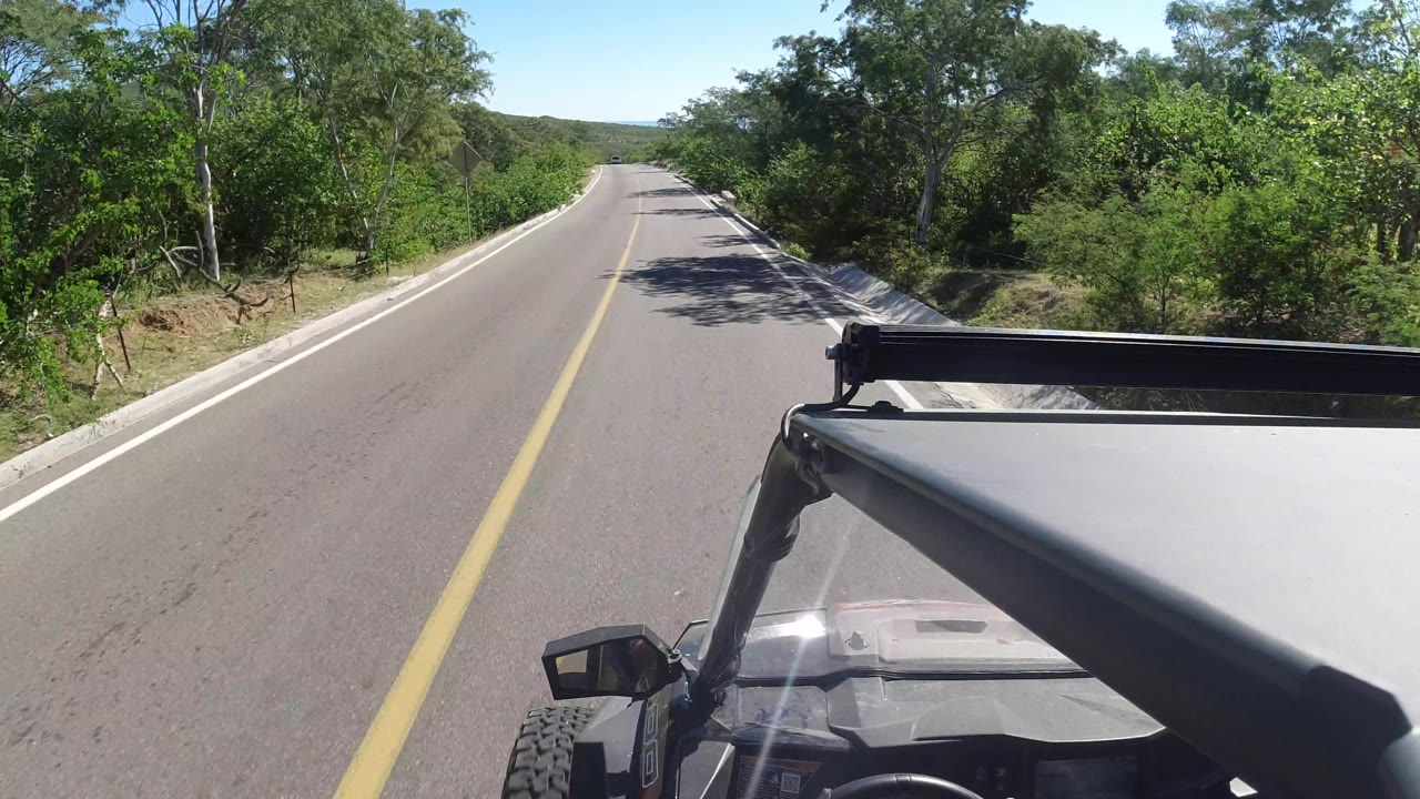 Empty highway stretching ahead with jeep frame visible at right.