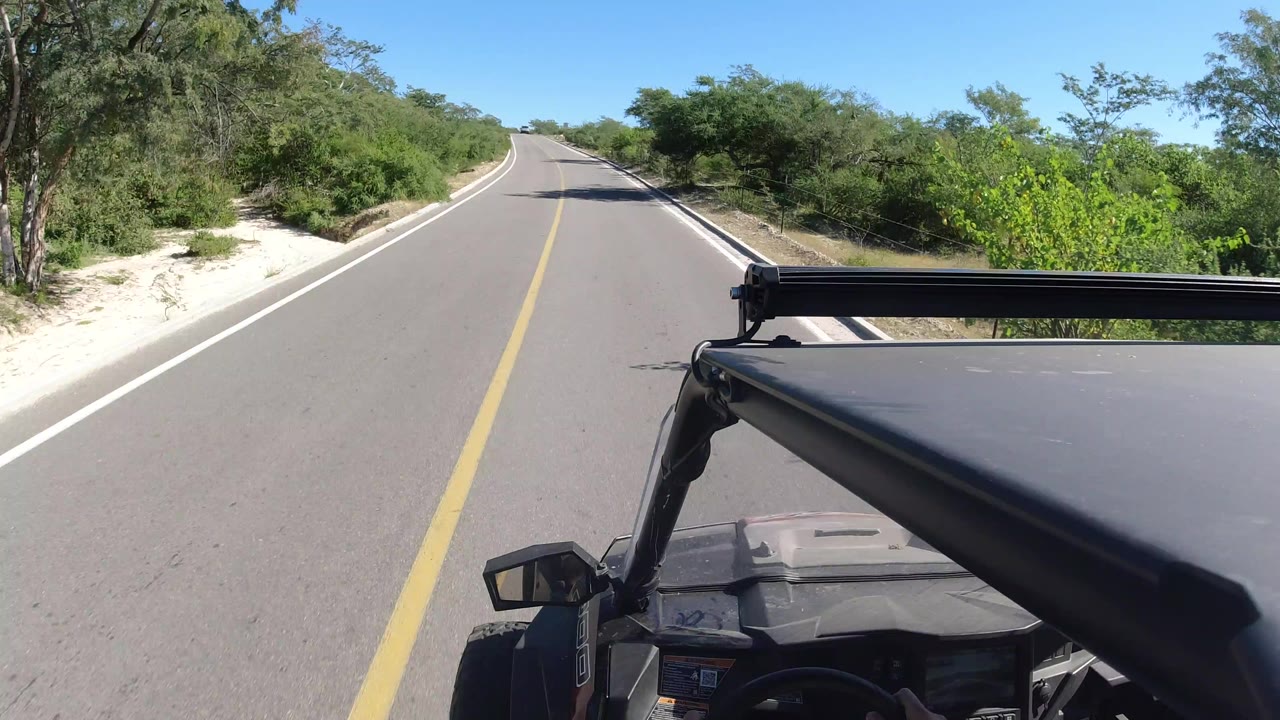 Empty paved road ahead with vehicle roof in foreground