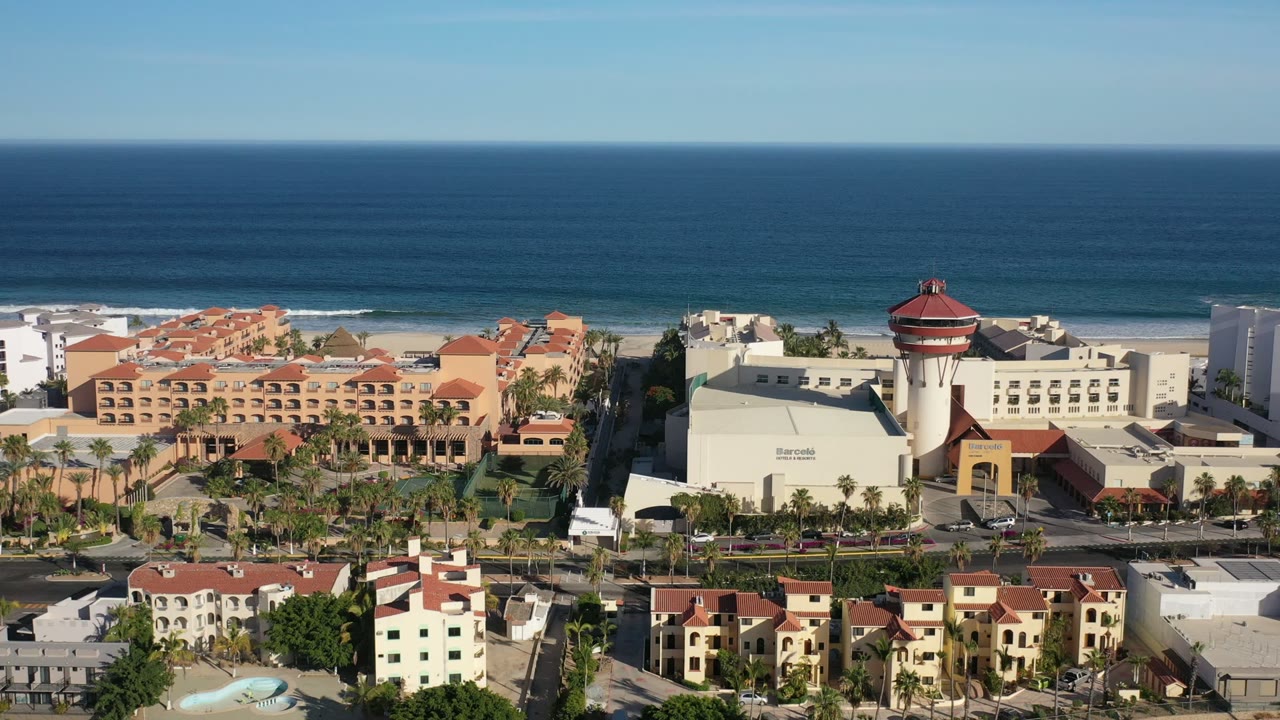 Aerial view of Los Cabos beachfront buildings beside the ocean.