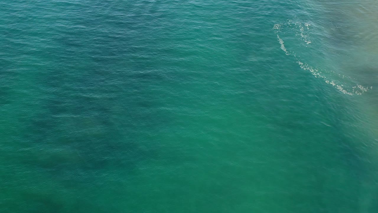Blue-green ocean surface in Los Cabos, Mexico, with small white highlights on the water and no visible people.