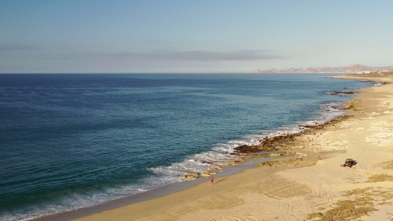 Aerial view of blue ocean meeting a sandy beach