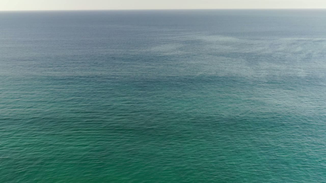 Green ocean surface with a soft horizon band.