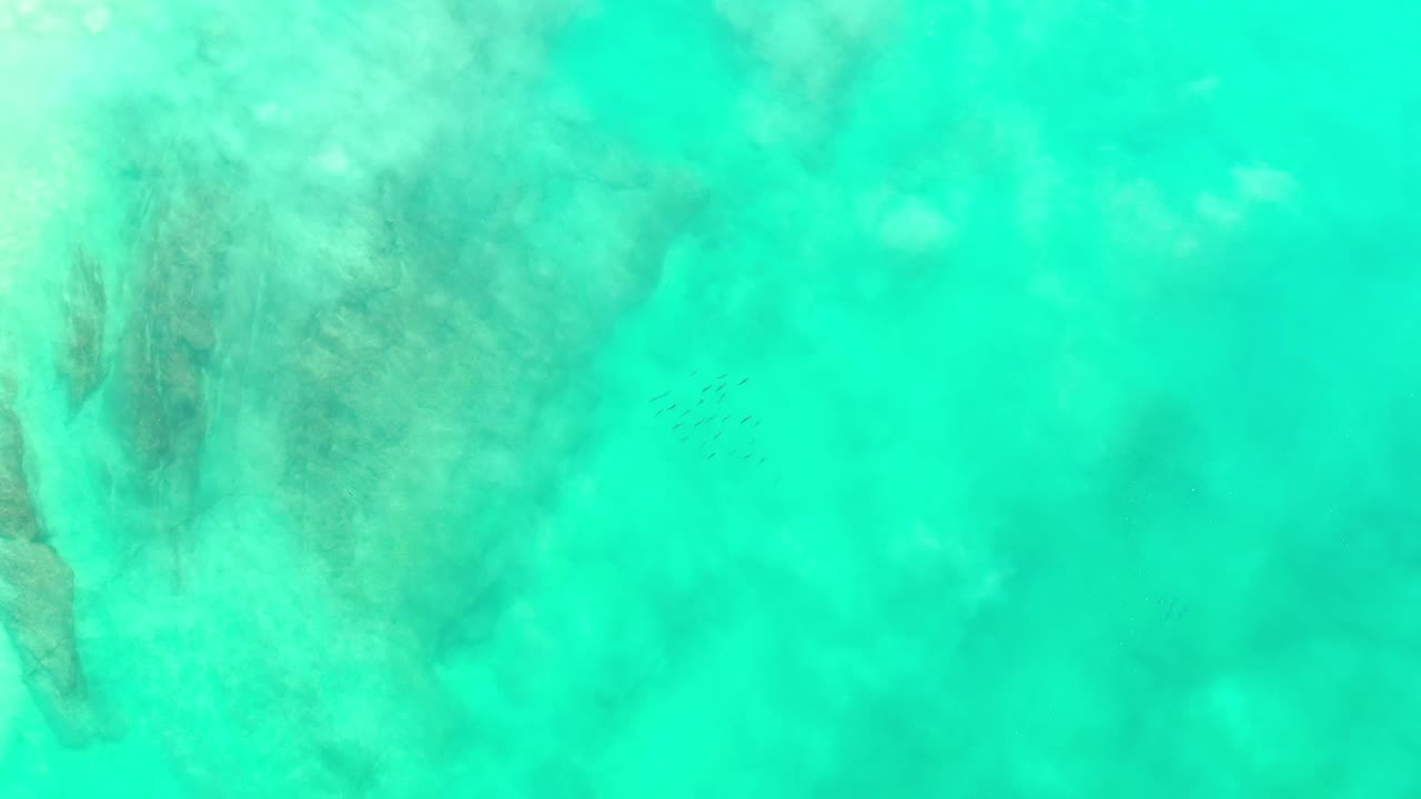 Turquoise-green seawater with darker submerged patches