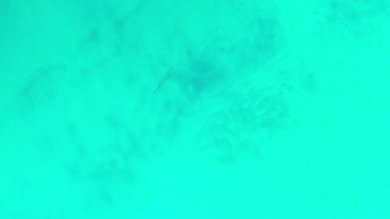 Turquoise ocean water fills the frame from above.