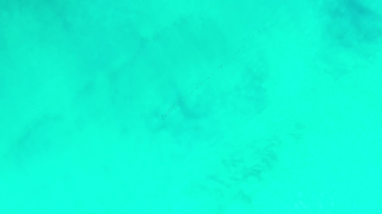 At 0:01, the Los Cabos water remains a flat aqua field with muted darker areas under the surface and no visible people.