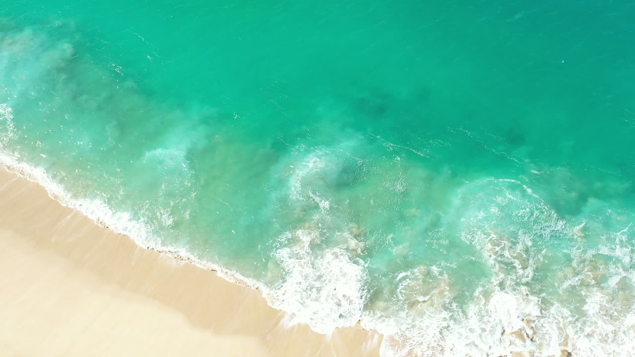 White foam spreading across a sandy shoreline.