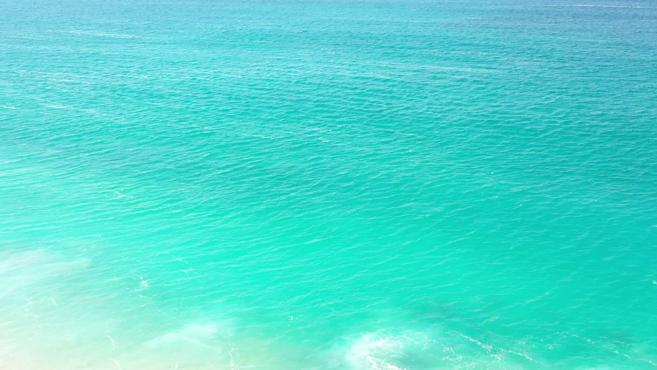Turquoise ocean water with a distant horizon and pale sky.
