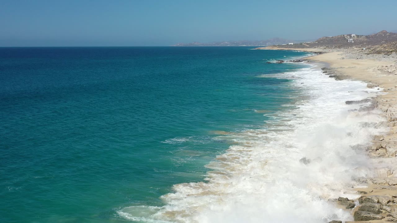 Aerial view of blue sea breaking along a rocky beach