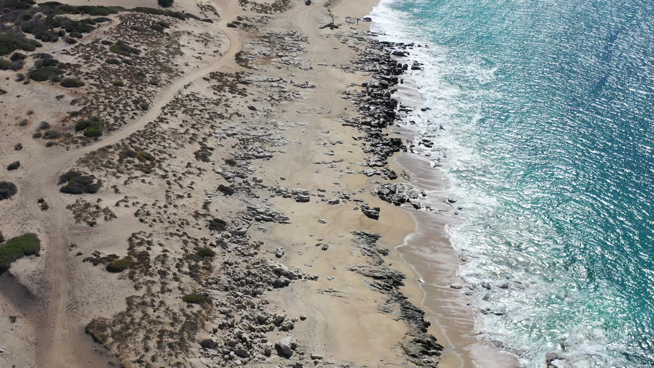 Aerial view of rocky beach and turquoise surf