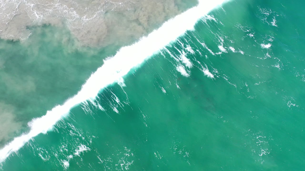 Overhead surf line breaking into green water
