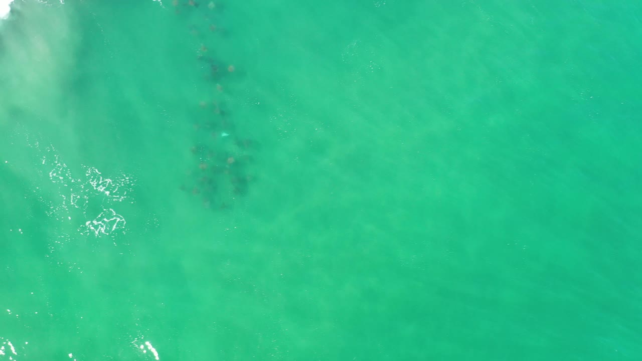 Turquoise water with a pale wash along the left edge and darker patches near center.