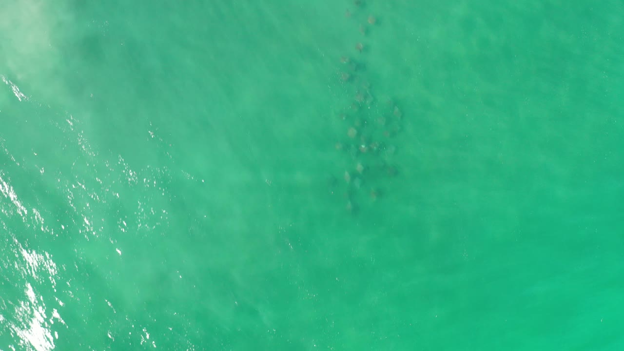 Top-down ocean view with a brighter diagonal band of reflected light.