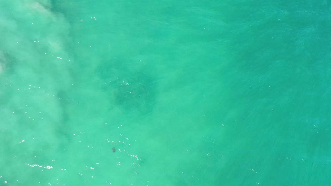 Overhead turquoise sea water with pale underwater clouding.
