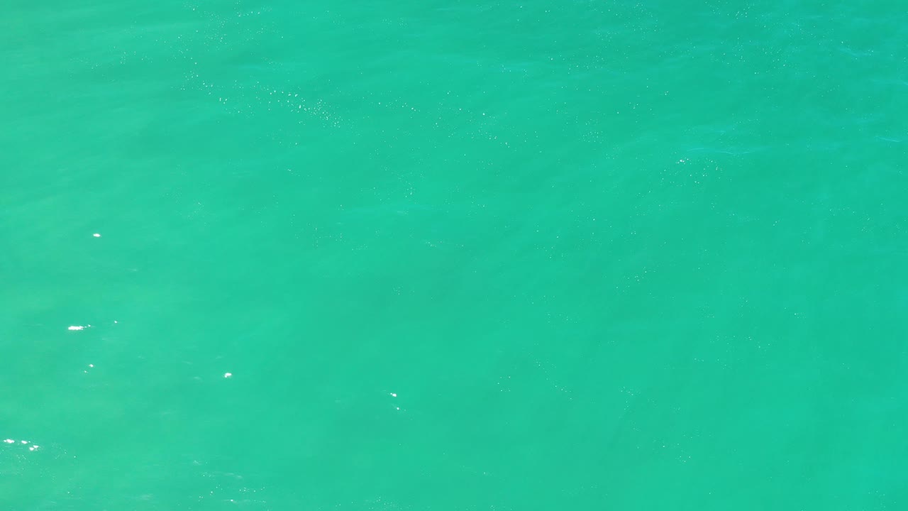 Green ocean surface with faint wave bands.