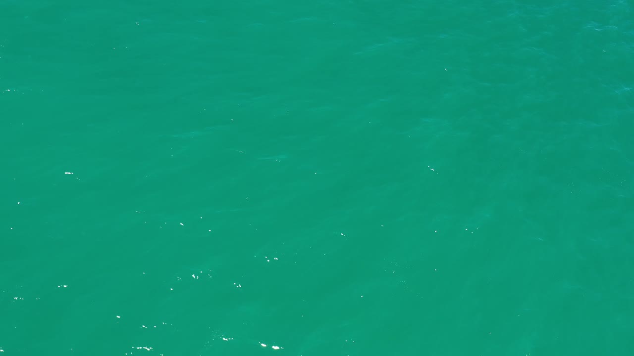 Turquoise ocean water in Los Cabos fills the second frame, with scattered highlights spread across a smooth rippled surface and no visible people.