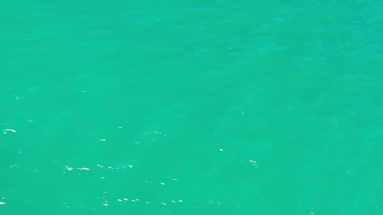 Overhead view of green-blue ocean water in Los Cabos, Mexico, with faint ripples and no visible people.