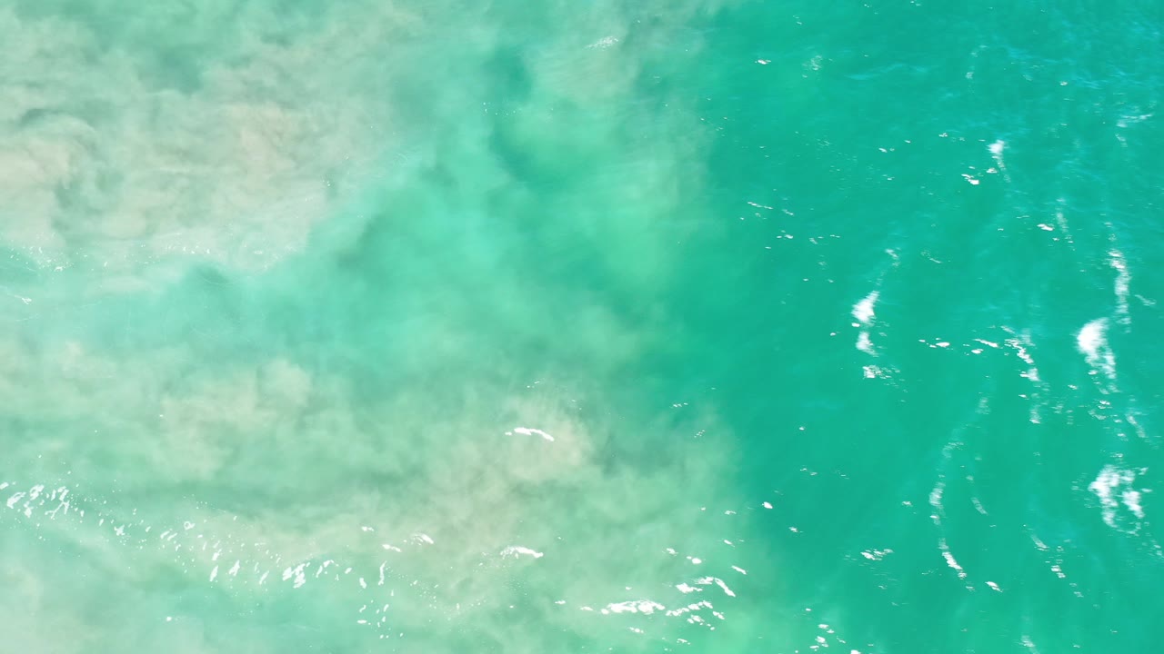 Turquoise green water with pale foam near the upper left.
