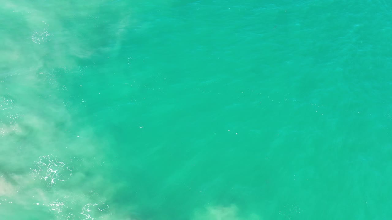 Turquoise water with pale foam gathering near the lower left edge.