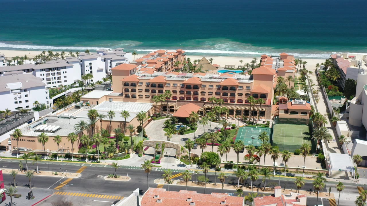 Elevated view of a beachfront resort complex beside ocean surf.