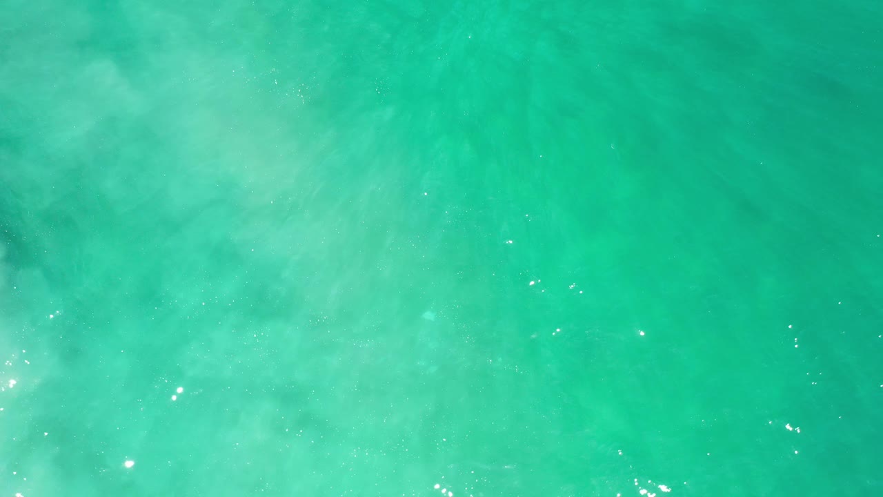Turquoise water with diffuse white-green clouding beneath the surface.