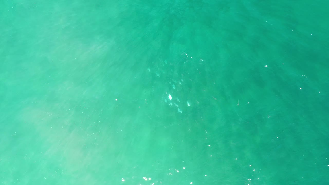 Dark turquoise water with soft ripples and faint light patches below.