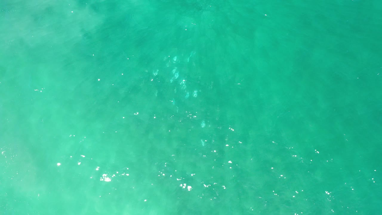 Overhead view of turquoise sea water in Los Cabos, Mexico, with soft pale current patterns and no visible people.