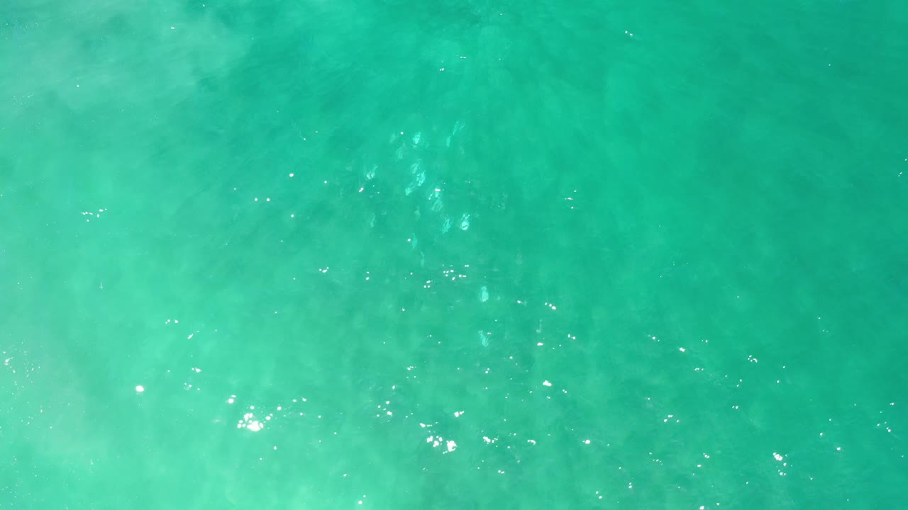 Blue-green sea surface in Los Cabos, Mexico, with cloudy underwater-looking current streaks and no visible people.