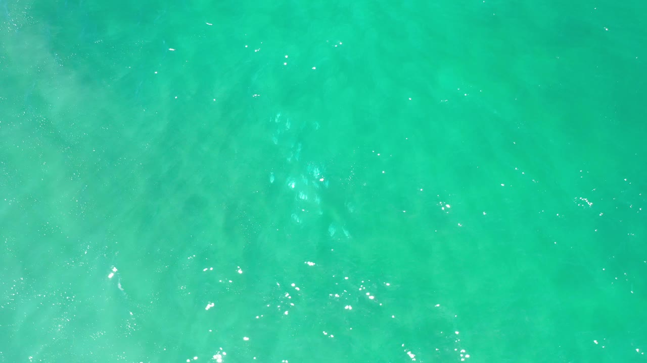 Aqua marine water with cloudy sand patterns beneath the surface.