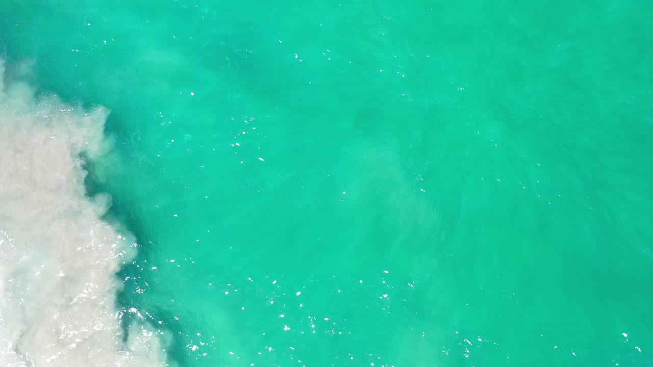 Foam edge and open blue-green sea surface.