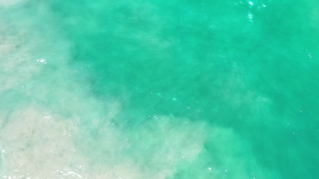 Foamy wave edge in clear turquoise water