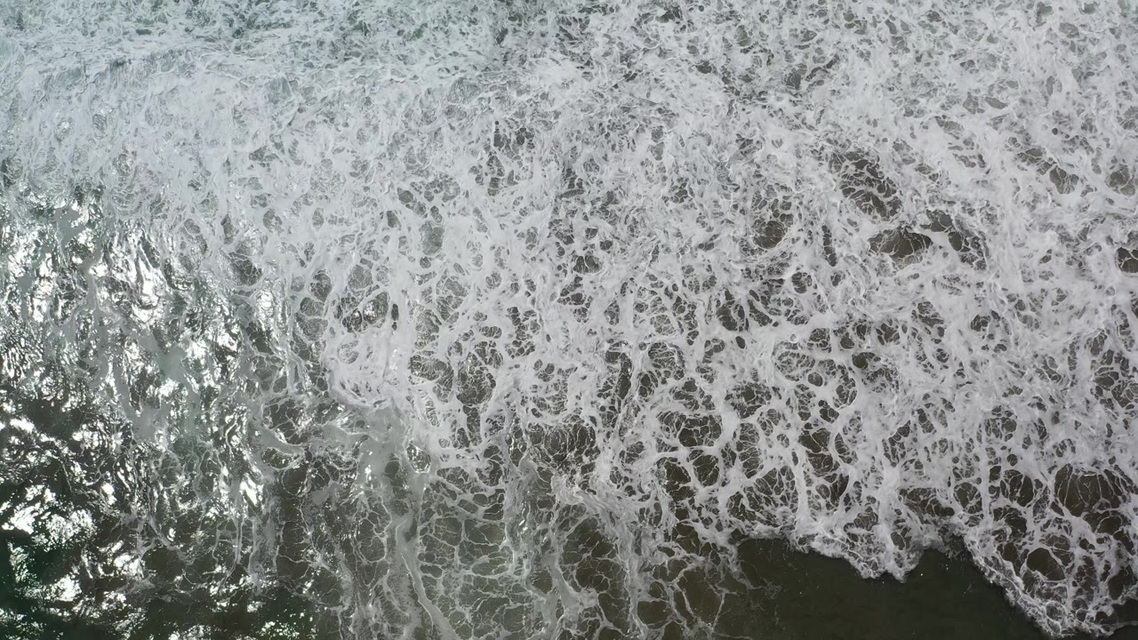 Sunlit rough sea water with whitewater filling the frame.