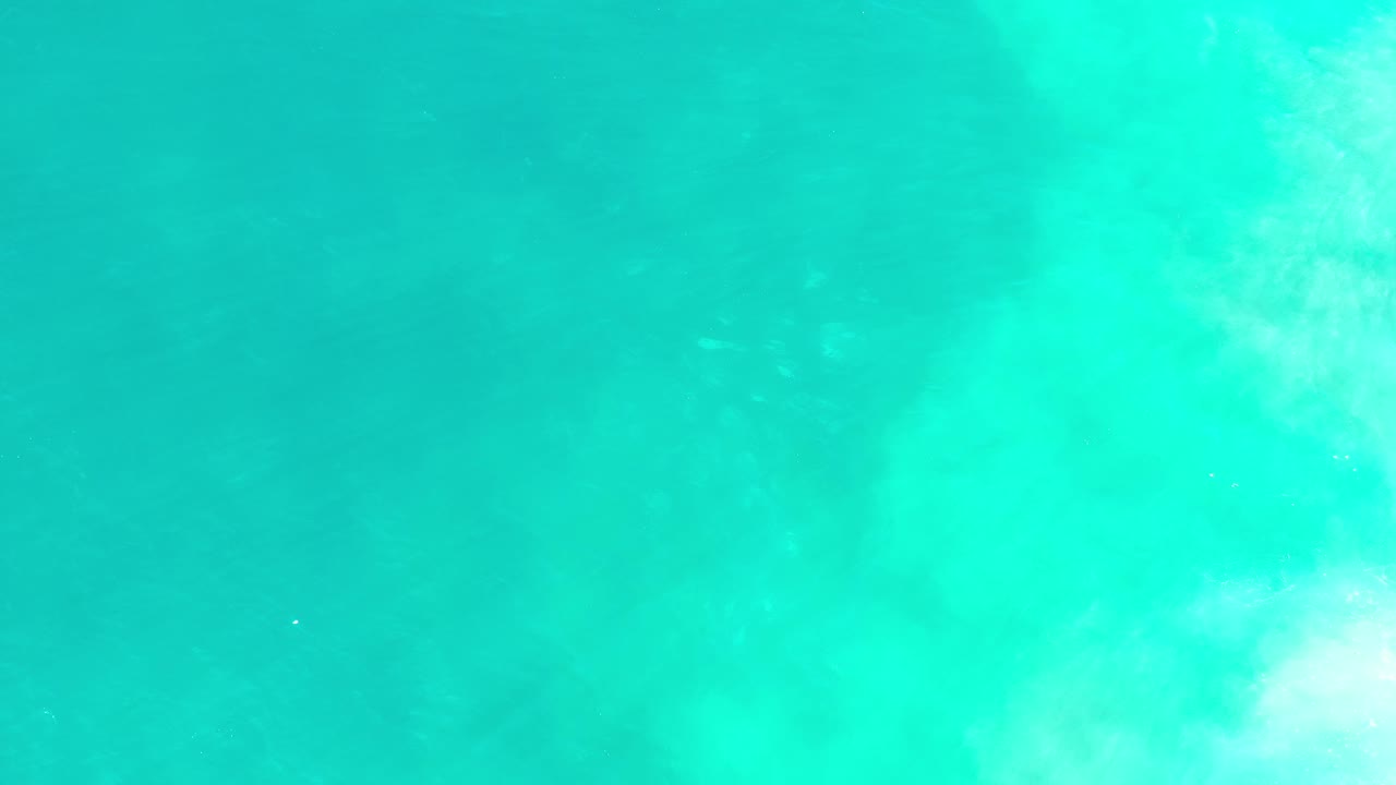 Bright turquoise water with faint white turbulence.