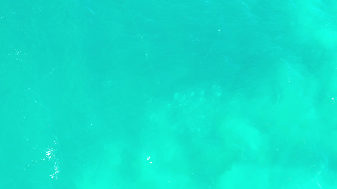 Turquoise water surface with pale underwater patches
