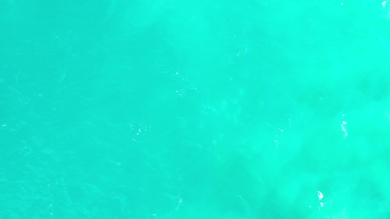 Aqua water fills the frame in Los Cabos, Mexico, with faint wind-made ripples and soft green-blue tonal shifts, no visible people.