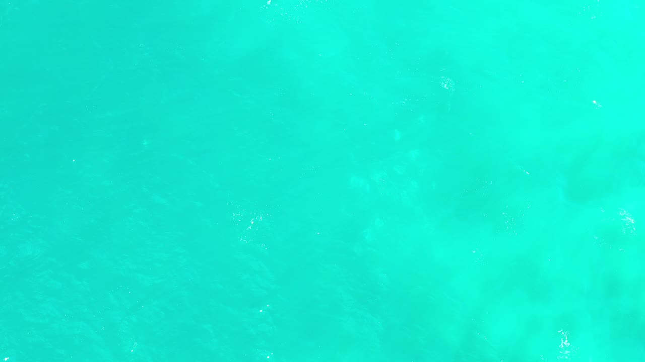 Bright turquoise water with small sunlit ripples.