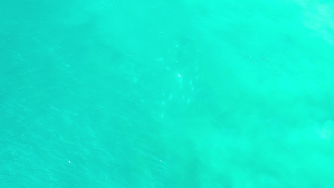 Turquoise water with brighter cloudlike areas below the surface.