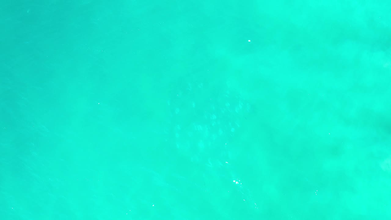 Clear aquamarine water with darker submerged patches