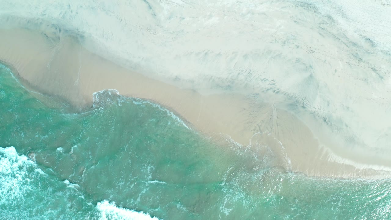 Top-down beach water with foamy wave