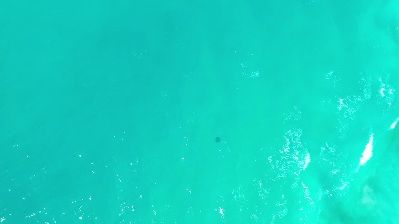 Turquoise water with cloudy lighter patches below the surface.