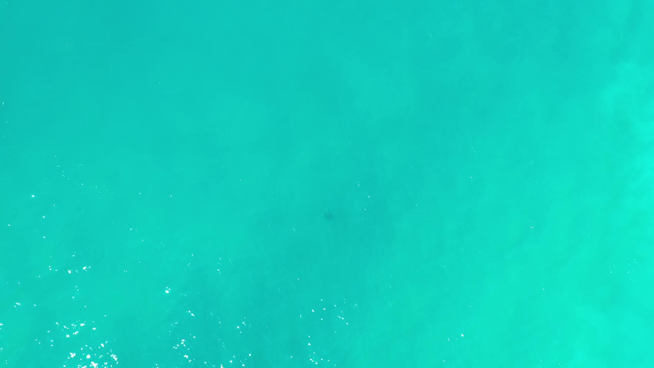 Top-down Los Cabos water frame with brighter sun flecks near the lower edge, soft teal gradients, and no visible people.