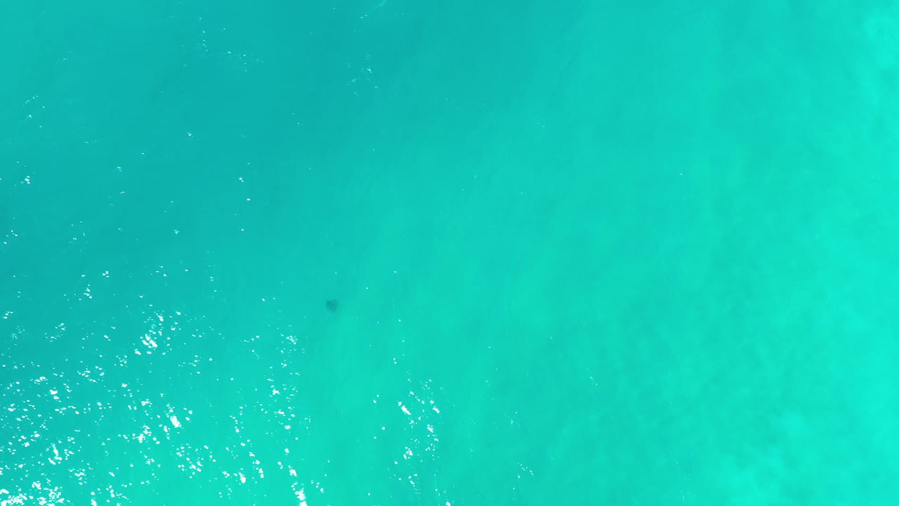 Overhead view of turquoise ocean water in Los Cabos, Mexico, with faint underwater texture and no visible people.