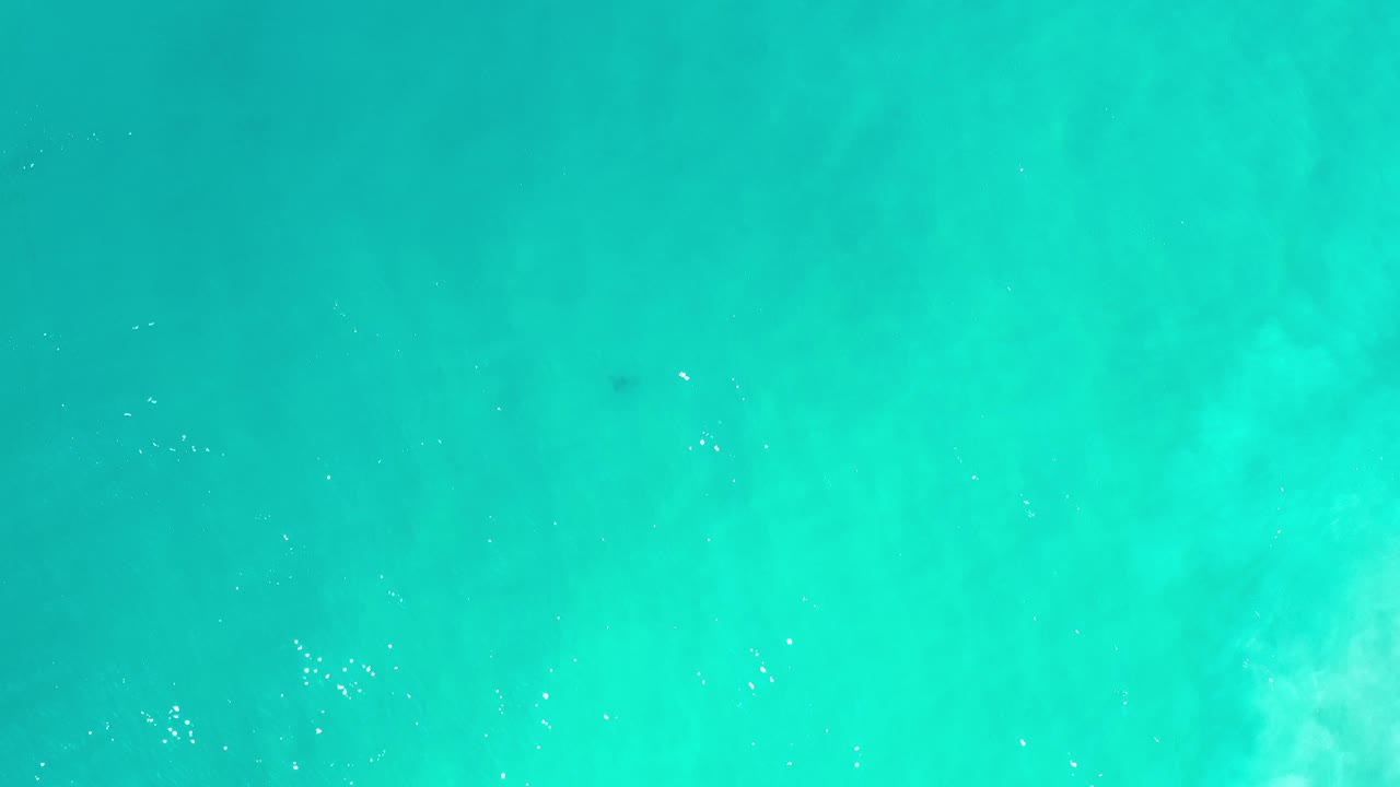 Overhead view of turquoise water in Los Cabos, Mexico, with faint pale underwater texture and no visible people.
