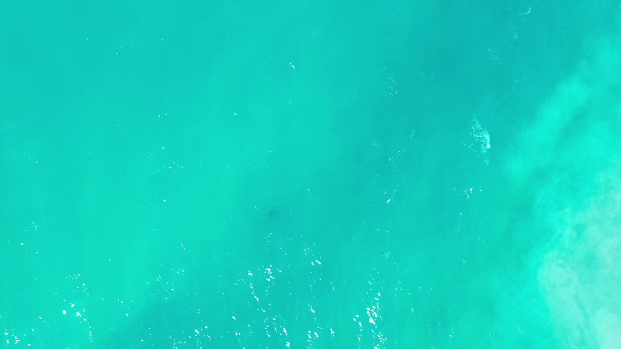 Bright teal water with diffuse pale wave shape