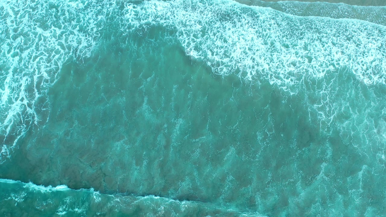 Overhead surf patterns and pale foam